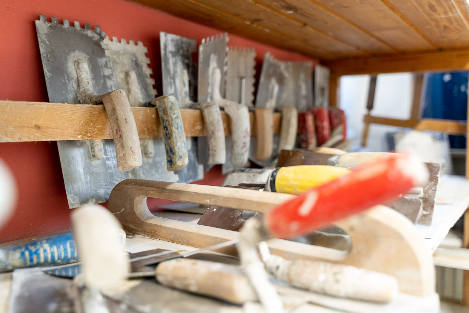  Spachtelkellen von Maler Merkle Illertissen sind sauber im Lagerregal für die nächsten Innenausbauarbeiten bereitgestellt. 