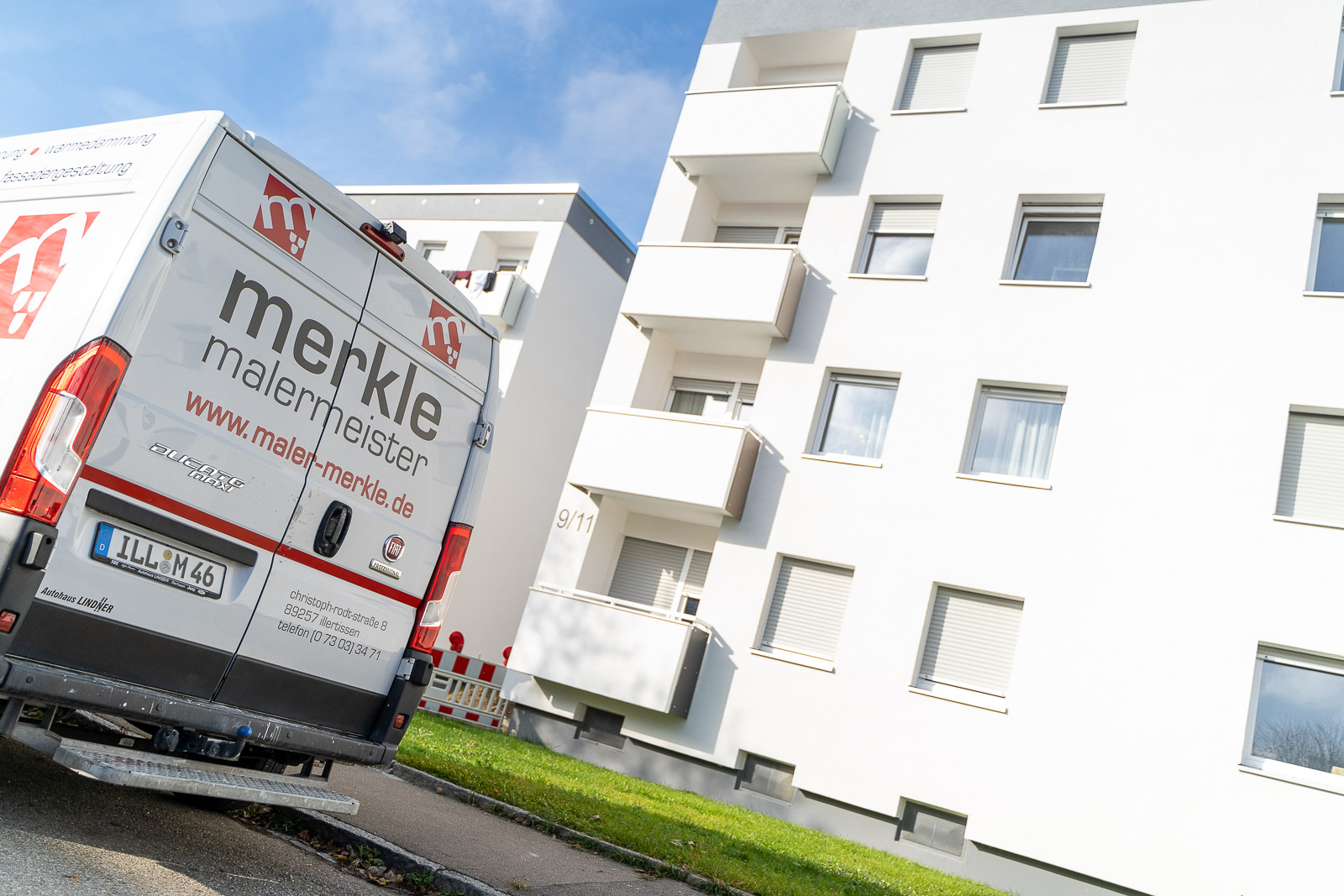  Der Lieferwagen von Maler Merkle Illertissen steht vor einem modernen Wohnkomplex bereit für Ausbau- und Innenraumarbeiten. 