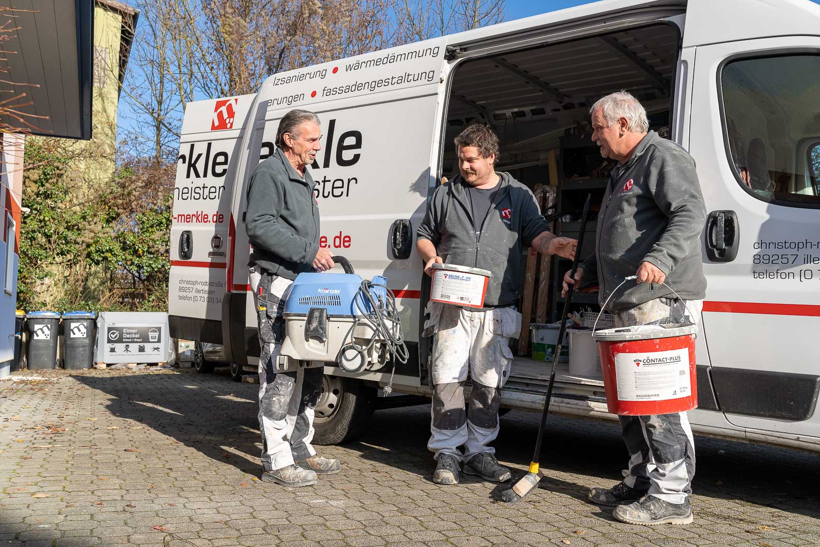  Drei Mitarbeiter von Maler Merkle Illertissen laden den Lieferwagen für einen bevorstehenden Innenausbau- und Renovierungsauftrag. 