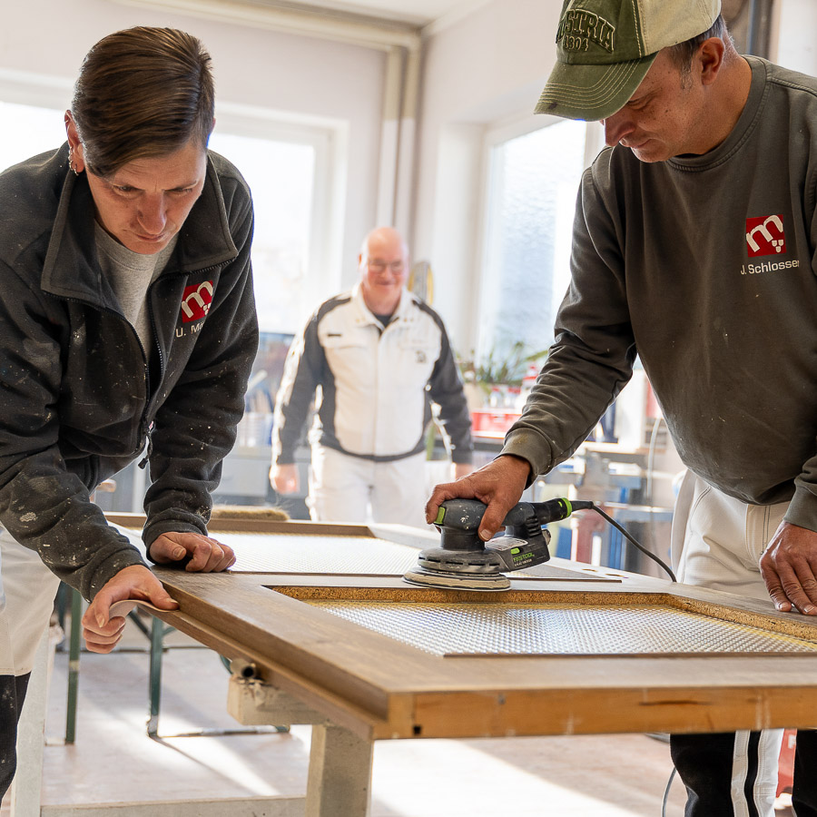 Zwei Mitarbeiter von Maler Merkle Illertissen bei der Arbeit – Symbol für stetige Weiterbildung und höchste fachliche Qualifikation.